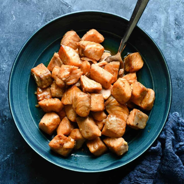 A blue bowl filled with cooked air fryer salmon bites.