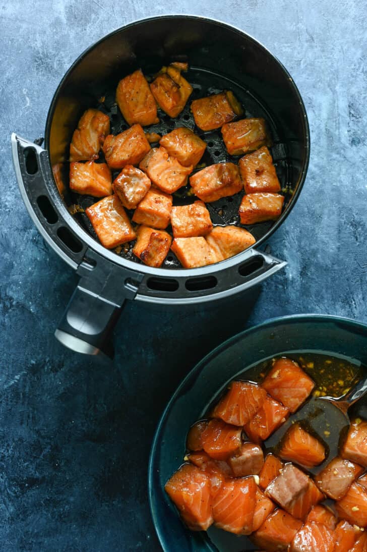 An air fryer basket filled with cooked salmon nuggets.