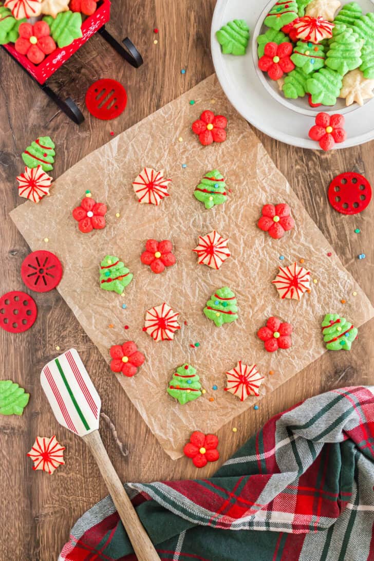 Spritz cookies on brown parchment paper, decorated for Christmas.