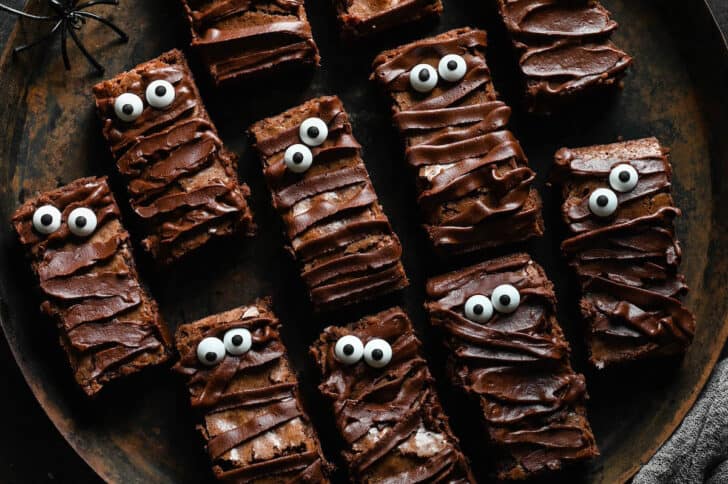 Mummy brownies on a rustic tray.