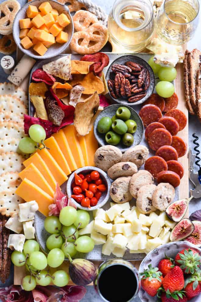 A unique charcuterie board made especially for wine tasting, including cheeses, veggie chips, olives, fruit, nuts, meat and crackers.
