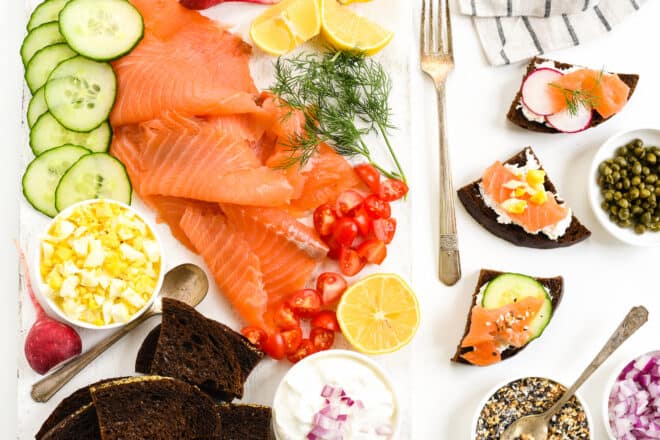 A party spread featuring a smoked salmon platter and pumpernickel bread.