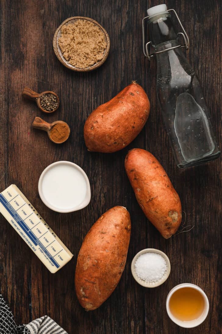 Ingredients laid out on a wooden surface, including root vegetables, butter, spices and brown sugar.